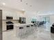 Open-concept kitchen with white cabinets, stainless steel appliances, quartz countertops, and bar seating at 1326 Butterfly Orchid Rd, Davenport, FL 33837
