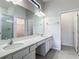 Bright, modern main bathroom with double vanity, large mirror, and walk-in shower at 1326 Butterfly Orchid Rd, Davenport, FL 33837