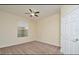 Neutral bedroom featuring carpet, ceiling fan, window, and a white door at 1357 Venezia Ct # 202, Davenport, FL 33896