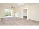 Bright bedroom features neutral carpet, light-colored walls, ceiling fan, balcony with sliding door, and chandelier at 1357 Venezia Ct # 202, Davenport, FL 33896