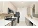 Compact kitchen with neutral tone cabinets, modern appliances, and a decorative backsplash at 1357 Venezia Ct # 202, Davenport, FL 33896