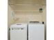 Efficient laundry room with modern washer, dryer, and convenient storage shelves at 1357 Venezia Ct # 202, Davenport, FL 33896