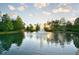 Beautiful pond featuring a fountain with trees reflecting the morning sky at 1357 Venezia Ct # 202, Davenport, FL 33896