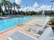 Relaxing pool area with lounge chairs for sunbathing and palm trees providing shade at 1357 Venezia Ct # 202, Davenport, FL 33896