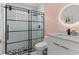 Trendy bathroom with a black frame glass shower and a contemporary vanity enhanced by a round lit mirror at 1559 Wescott Loop, Winter Springs, FL 32708