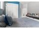 Modern bedroom featuring a stylish blue accent wall, sleek floating shelves, and contemporary design at 1559 Wescott Loop, Winter Springs, FL 32708