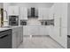 Modern kitchen features sleek white cabinetry, stainless steel appliances, and an island at 1559 Wescott Loop, Winter Springs, FL 32708