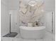 Modern bathroom featuring a stand-alone tub, marble accent wall, and sleek fixtures at 1559 Wescott Loop, Winter Springs, FL 32708