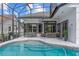 Wide view of backyard showcasing pool, patio, seating, and surrounding privacy landscaping at 1559 Wescott Loop, Winter Springs, FL 32708