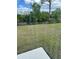 View of back yard with black metal fence, grass and view of trees and sky at 1723 Post Oak Dr, Davenport, FL 33837
