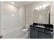 Modern bathroom featuring a shower-tub combo and vanity with black countertop at 2019 Spring Shower Cir, Kissimmee, FL 34744