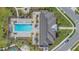 Overhead view of the community pool and lounge area featuring ample seating, palms, and a clubhouse at 2019 Spring Shower Cir, Kissimmee, FL 34744