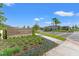 Street view of the community entrance with landscaping, signage, and crosswalk at 2019 Spring Shower Cir, Kissimmee, FL 34744