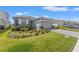 Well-manicured front yard and neutral-colored home with a two car garage under a sunny blue sky at 2019 Spring Shower Cir, Kissimmee, FL 34744