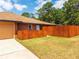 Side view of a backyard showcasing a privacy fence, well-maintained lawn, and home exterior features at 20249 Macon Pkwy, Orlando, FL 32833