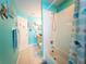 Fresh bathroom with turquoise walls, a sleek glass sink, and a shower-tub combo behind a themed curtain at 20249 Macon Pkwy, Orlando, FL 32833