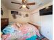 Charming bedroom with wooden bed, ceiling fan, mounted TV, and closet featuring sliding doors at 20249 Macon Pkwy, Orlando, FL 32833