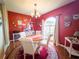 Red-toned dining room features chandelier, decor, table, seating for four, and large window at 20249 Macon Pkwy, Orlando, FL 32833