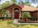 Charming home featuring a red front door, stone accents, well-kept lawn, and American flag at 20249 Macon Pkwy, Orlando, FL 32833