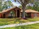 Beautiful one-story home featuring a manicured lawn, red door, stone accents, and an American flag at 20249 Macon Pkwy, Orlando, FL 32833