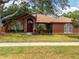 Single-story home with a well-manicured lawn, a red front door, and stone accents at 20249 Macon Pkwy, Orlando, FL 32833