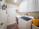 Bright laundry room with washer and dryer, storage cabinets, and a decorated wall at 20249 Macon Pkwy, Orlando, FL 32833