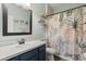 Bathroom with vanity, decorative shelves, and floral shower curtain at 206 Bonville Dr, Davenport, FL 33897