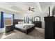 Comfortable main bedroom with a tray ceiling, large windows, and dark wood furniture at 206 Bonville Dr, Davenport, FL 33897