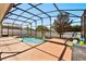 Enjoy this refreshing screened-in pool with a relaxing seating area and a backyard view at 206 Bonville Dr, Davenport, FL 33897