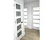 Hallway with white doors, glass panels, modern black hardware, and light wood flooring at 2227 Coventry Dr, Winter Park, FL 32792