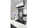 Close-up of a modern kitchen with an island cooktop, stainless steel refrigerator, and ample cabinet space at 2227 Coventry Dr, Winter Park, FL 32792