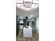 Bright kitchen featuring modern lighting, an island with seating, stainless steel appliances, and a view of the stairs at 2227 Coventry Dr, Winter Park, FL 32792