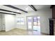 Bright living room with wood-look flooring, beamed ceilings, access to a patio, and a view of the backyard at 2227 Coventry Dr, Winter Park, FL 32792