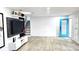 Bright living room featuring modern decor, a blue door, stylish TV, and beautiful flooring at 2227 Coventry Dr, Winter Park, FL 32792
