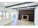 Living room with brick fireplace, beamed ceilings, hardwood floors, and a sliding glass door to the patio at 2227 Coventry Dr, Winter Park, FL 32792