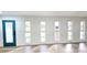 Bright living room with a blue door, five windows, and light wood flooring at 2227 Coventry Dr, Winter Park, FL 32792