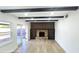 Bright living room with wood-look flooring, brick fireplace, dark wood beams and access to the backyard at 2227 Coventry Dr, Winter Park, FL 32792