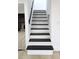 Staircase featuring light risers, dark treads, and a contrasting black handrail at 2227 Coventry Dr, Winter Park, FL 32792