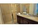 Modern bathroom with double sinks, granite countertop, tiled shower, and sleek fixtures at 228 Captiva Dr, Davenport, FL 33896
