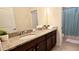 Bright bathroom featuring a double vanity with granite countertop, elegant faucets, and a separate shower area, offering a luxurious experience at 228 Captiva Dr, Davenport, FL 33896