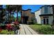 Clubhouse exterior featuring an Arcade, a brick entrance and a walkway surrounded by green bushes and red flowers at 228 Captiva Dr, Davenport, FL 33896