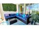 Covered patio with comfortable outdoor seating, a stylish area rug, and lush green wall at 228 Captiva Dr, Davenport, FL 33896