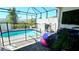 Screened-in private pool area with safety fence, lounge seating, and well-maintained landscaping at 228 Captiva Dr, Davenport, FL 33896