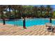 Large swimming pool with clear blue water, sun loungers and palm trees inviting relaxation and recreation at 228 Captiva Dr, Davenport, FL 33896