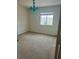 Bedroom features neutral carpet, a window, and a unique turquoise chandelier, creating a stylish space at 2305 Chatham Place Dr, Orlando, FL 32824