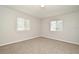 Bright bedroom showcasing neutral carpet and two windows for natural light at 2305 Chatham Place Dr, Orlando, FL 32824
