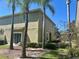 View of home's exterior, featuring palm trees, a sliding glass door and lush green grass at 2305 Chatham Place Dr, Orlando, FL 32824