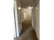 Hallway featuring neutral carpet, white walls, and access to multiple rooms and storage at 2305 Chatham Place Dr, Orlando, FL 32824