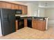 Functional kitchen featuring wood cabinets, black appliances, and tile flooring at 2305 Chatham Place Dr, Orlando, FL 32824