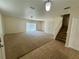 Spacious living room with carpet floors, sliding glass doors to lanai and staircase to second floor at 2305 Chatham Place Dr, Orlando, FL 32824